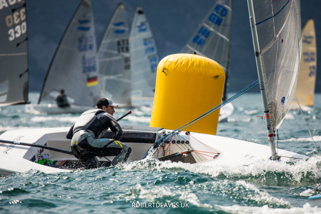 Finn sailor rounding mark, about to gybe.