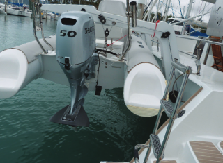 Dinghy at the back of a boat, very close to the water.