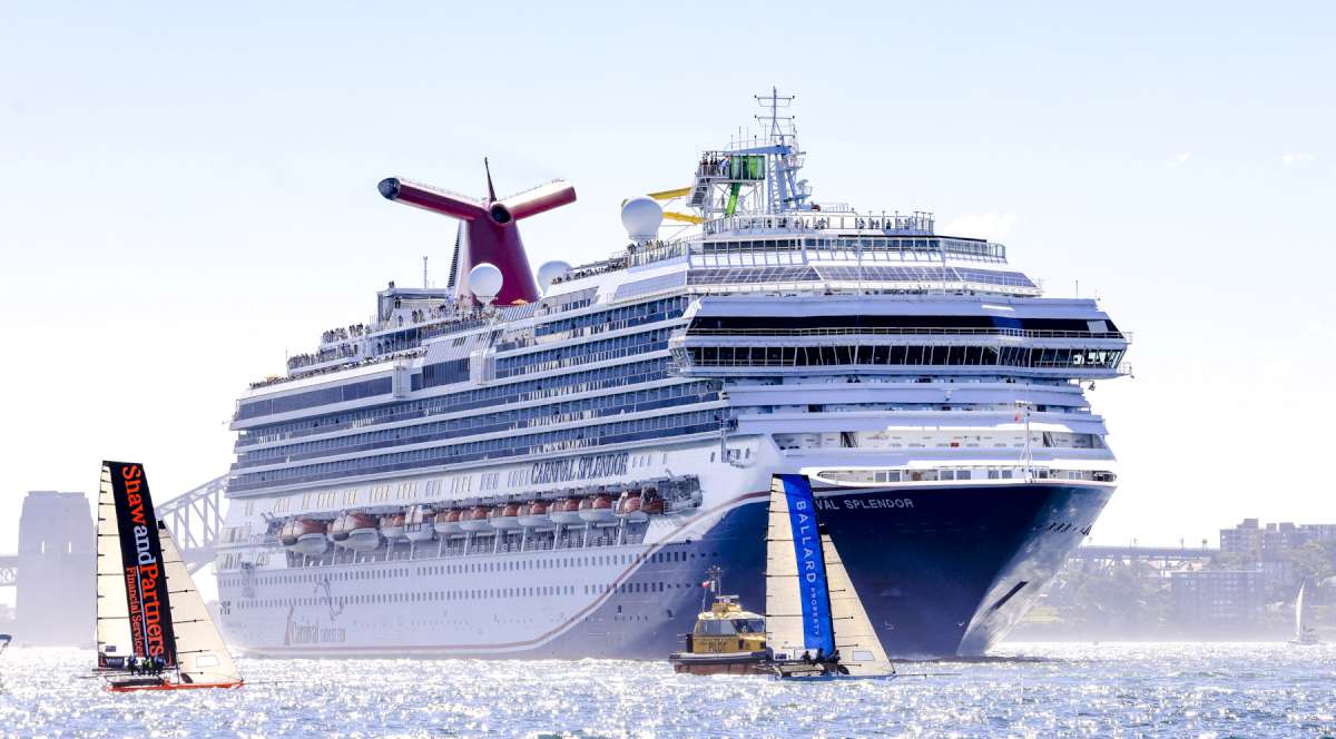 Skiffs challenge the cruise ship (SailMedia)